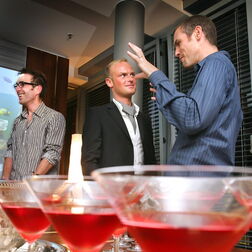 Gespräche bei einer Privatfeier mit Cocktailgläsern im Vordergrund