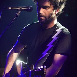 Sänger auf Bühne mit Gitarre und Mikrofon