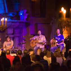 Band auf Bühne mit Kerzenlicht
