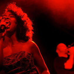 Band „DePhazz“ - Sängerin in rotem Licht mit Posaunist m Hintergrund