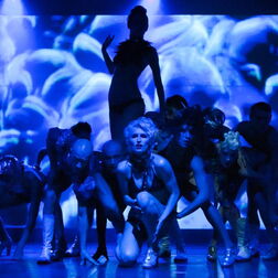 Tanzende Frauen in blauem Licht im Bühnenprogramm bei einer Gala der DHL im Tipi am Kanzleramt in Berlin