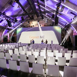Ein leerer Saal mit Stühlen und Bühne bei einer Veranstaltung von Gigaset